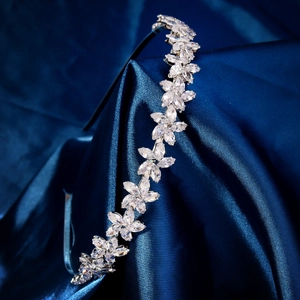 Détail d'un serre-tête de mariée argenté avec cristaux sur satin de soie bleu