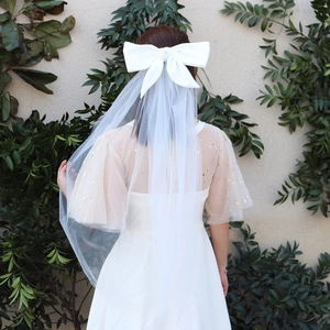 Détail d'un voile de mariée blanc avec grand nœud en satin et tulle transparent