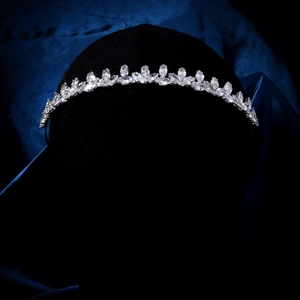 Close-up of elegant leaf-shaped zircon crown on a luxury navy silk background