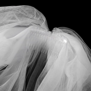 Détail d'un voile de mariée blanc multicouche avec peigne en plastique transparent fixé