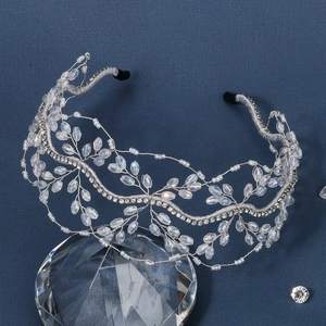 Detail of beaded bridal crown headband with crystals and pearls on blue background