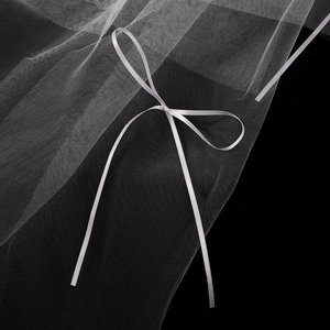 Gros plan d'un voile de mariée blanc avec une maille douce et un élégant nœud en satin