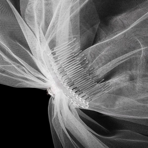 Détail d'un voile de mariée blanc en maille légère avec peigne en plastique transparent