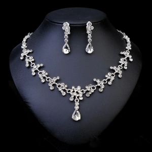 Détail de parure de mariée argentée avec strass en goutte d'eau et collier floral