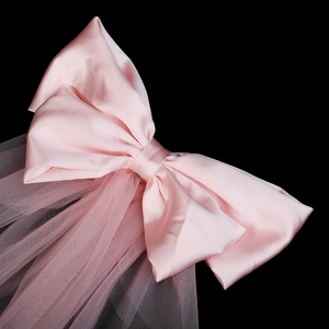 Détail du voile à nœud en satin rose avec tulle superposé pour mariage et fête