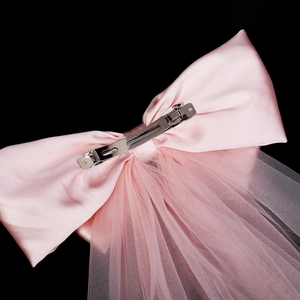 Détails de l'envers du nœud en satin rose avec voile et pince à ressort métallique