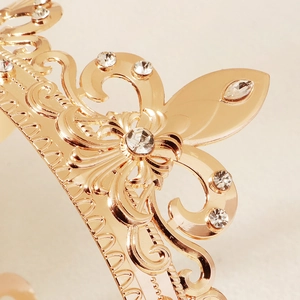 Detailed close-up of Baroque gold crown featuring intricate rhinestones and floral patterns