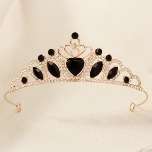 Close-up of golden crown headband with sparkling rhinestones and black heart gemstone
