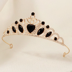 Macro detail of golden vintage crown with sparkling white rhinestones and black heart gems