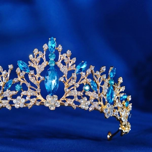 Gros plan détaillé d'une couronne dorée ornée de grandes gemmes bleues et de strass fins