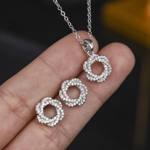 Detailed close-up of micro-pave zircon necklace and earrings set in 18K gold plating
