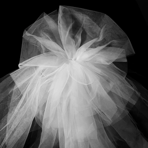 Détail du voile de mariée en tulle blanc multicouche montrant la texture fine du filet