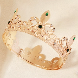 Vintage Baroque gold crown with emerald gemstones and intricate floral relief patterns