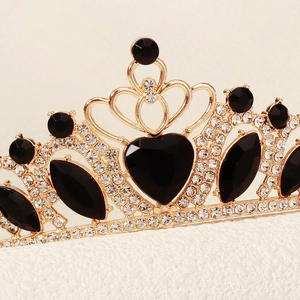 Close-up of gold princess crown featuring black heart crystal and sparkling rhinestones