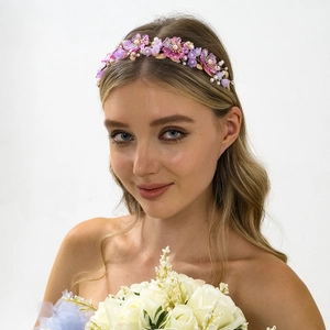 Detailaufnahme von handgefertigtem lila Blumen Stirnband mit Perlen und Goldblättern
