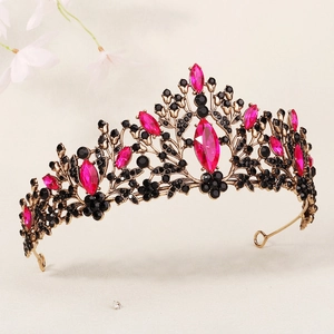 Vue détaillée de la couronne dorée antique avec des strass rose fuchsia et noirs