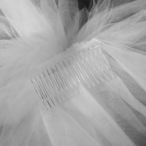 Vue macro détaillée du peigne de mariée transparent et de la texture du voile en maille blanche