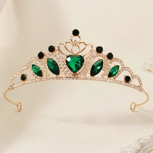 Detailed view of a golden princess crown with emerald heart gems and sparkling rhinestones