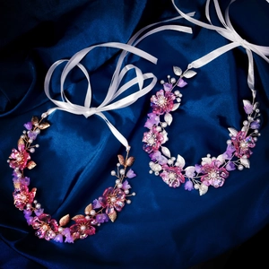 Exquisite Blumenhaarbänder mit Harzblumen und Perlen auf blauem Satinhintergrund