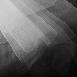 Gros plan sur le tissu tulle blanc fin montrant la texture délicate du filet