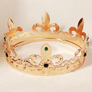 Detailed macro view of baroque golden crown featuring fleur-de-lis and green gemstones