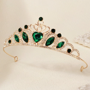 Detail of vintage gold tiara with heart-shaped green crystal and sparkling rhinestones