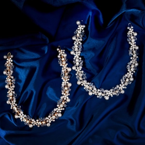 Elegant bridal hair vine set with pearls and crystals on dark blue satin background