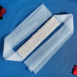 Vue détaillée du voile de mariée blanc avec perles délicates sur un fond bleu foncé