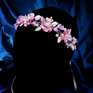 Detailaufnahme des handgefertigten Blumenhaarschmucks mit rosa Blüten und Perlen