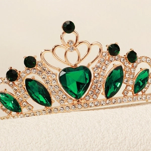 Macro shot of gold tiara with heart green gemstones and white rhinestones for kids