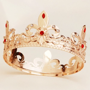 Close-up of vintage baroque gold crown with intricate filigree and red gemstones