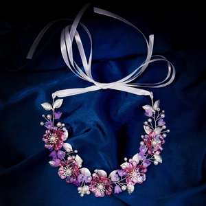 Detail von floralem Kopfschmuck mit lila Blüten und Perlen für Hochzeiten und Feiern