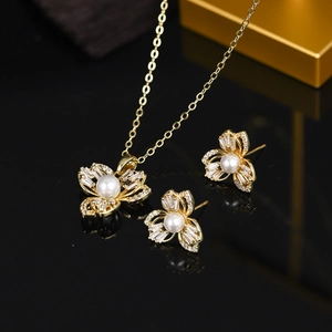 Detail of elegant gold flower jewelry set with sparkling crystals and white pearls