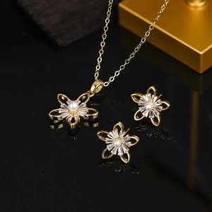 Close-up of gold flower jewelry set with central pearls and cubic zirconia stones