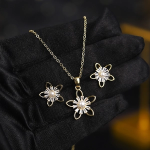 Detailed close-up of a six-petal flower jewelry set with pearls and clear stones