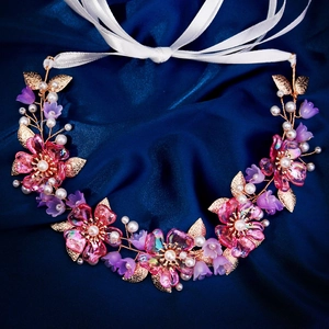 Blumenkranz mit rosa Harzblumen, Perlen und Goldblättern auf blauem Seidenhintergrund