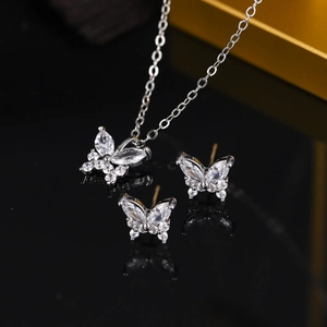 Close-up of vintage butterfly necklace and earrings set with zircons in 18K gold finish