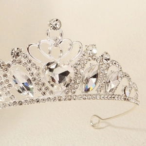 Close-up of elegant silver tiara crown with heart-shaped crystal and rhinestone details