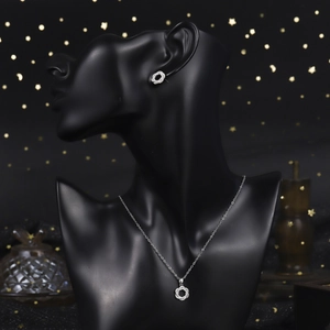Detail of luxury zircon necklace and earring set on a black mannequin with starry background