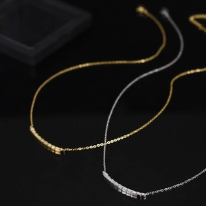 Detail von Gold- und Silberschlangenschuppenanhängern mit weißen Zirkoniasteinen