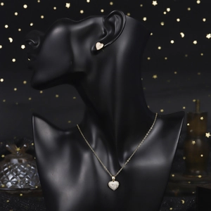 Close-up of vintage 18K gold heart jewelry set with pave zircon on elegant black display