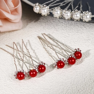 Vue macro d'épingles à cheveux en U argentées avec perles rouges et blanches et strass
