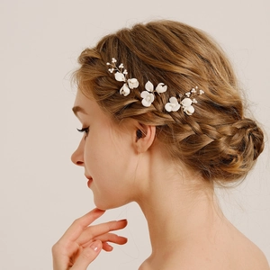 Detail view of handmade flower hair pins with pearls and crystals on bridal hairstyle