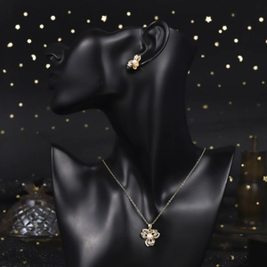 Detail of flower shaped gold necklace and earrings with pave zircon and white pearls