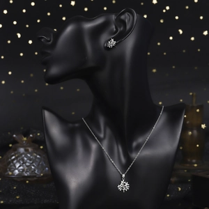 Detailed view of silver tree of life jewelry set with sparkling pavé zircons on black mannequin