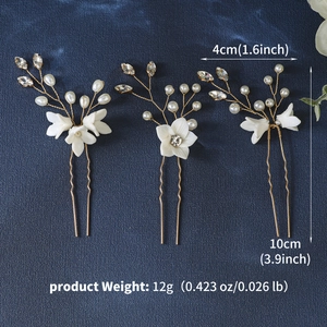 Detailed view of handmade flower bridal hair pins with pearls and crystals on blue background