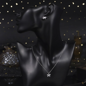 Elegant silver bow jewelry set with sparkling cubic zirconia on a black mannequin model
