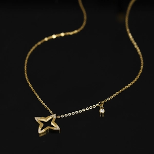 Makro-Detail des goldenen Titan-Sternanhängers mit mattem Finish und funkelndem Zirkon