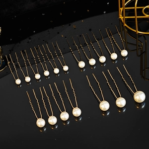 Détail d'épingles à cheveux en perles de tailles variées sur une surface noire brillante