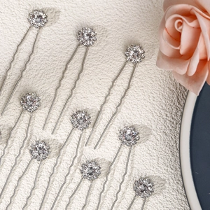 Close-up of elegant bridal U-shaped hair pins with sparkling rhinestones and floral design